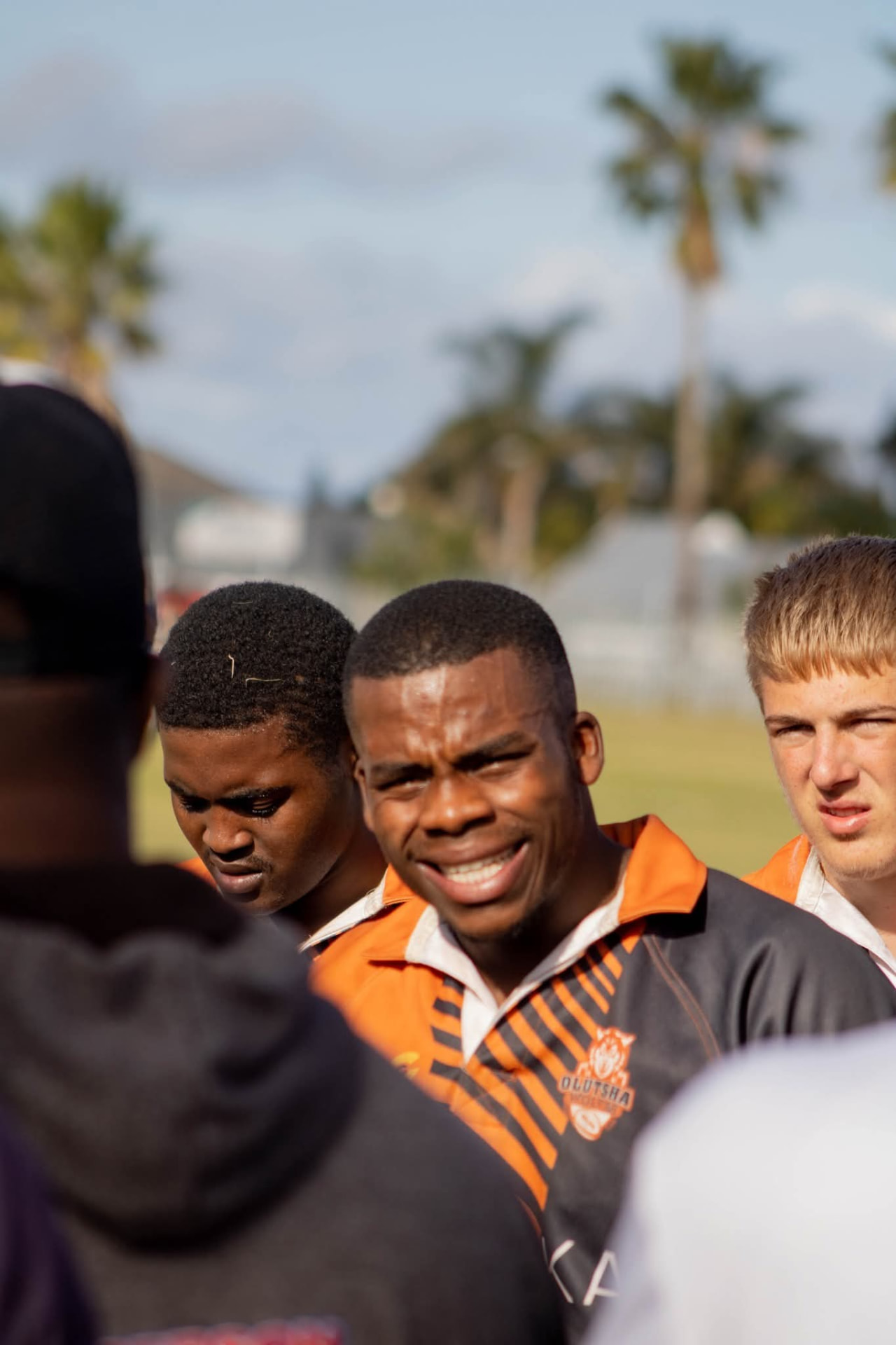 Olutsha Under-21 players in orange and black kit in a team talk